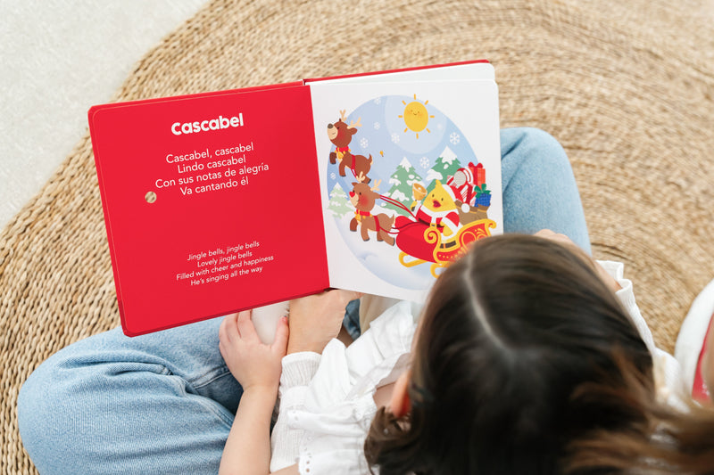 Mom & daughter spend time together reading a bilingual childrens book featuring Christmas songs in Spanish