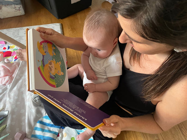 Mother reads bilingual baby books with her daughter to teach her Spanish early on