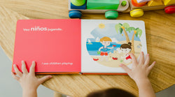 Bilingual child plays a sound book as he explores Binibi's the Visiting- Visitando La Playa sound book. 