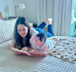 Mom reads bilingual musical book with her baby to practice Spanish at home