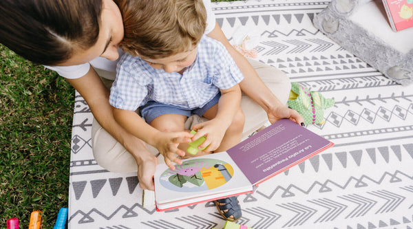 Bilingual mother and son browse through one of Binibi's interactive musical books for toddlers, Los Pollitos Dicen, that features catchy Spanish nursery rhymes.