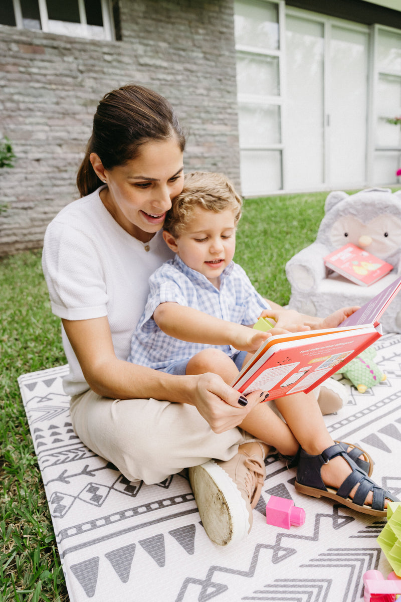 Bilingal mother and son share quality time as they read Binibi's bilingual children's book, Los Pollitos Dicen, featuring popular Spanish songs for kids. 